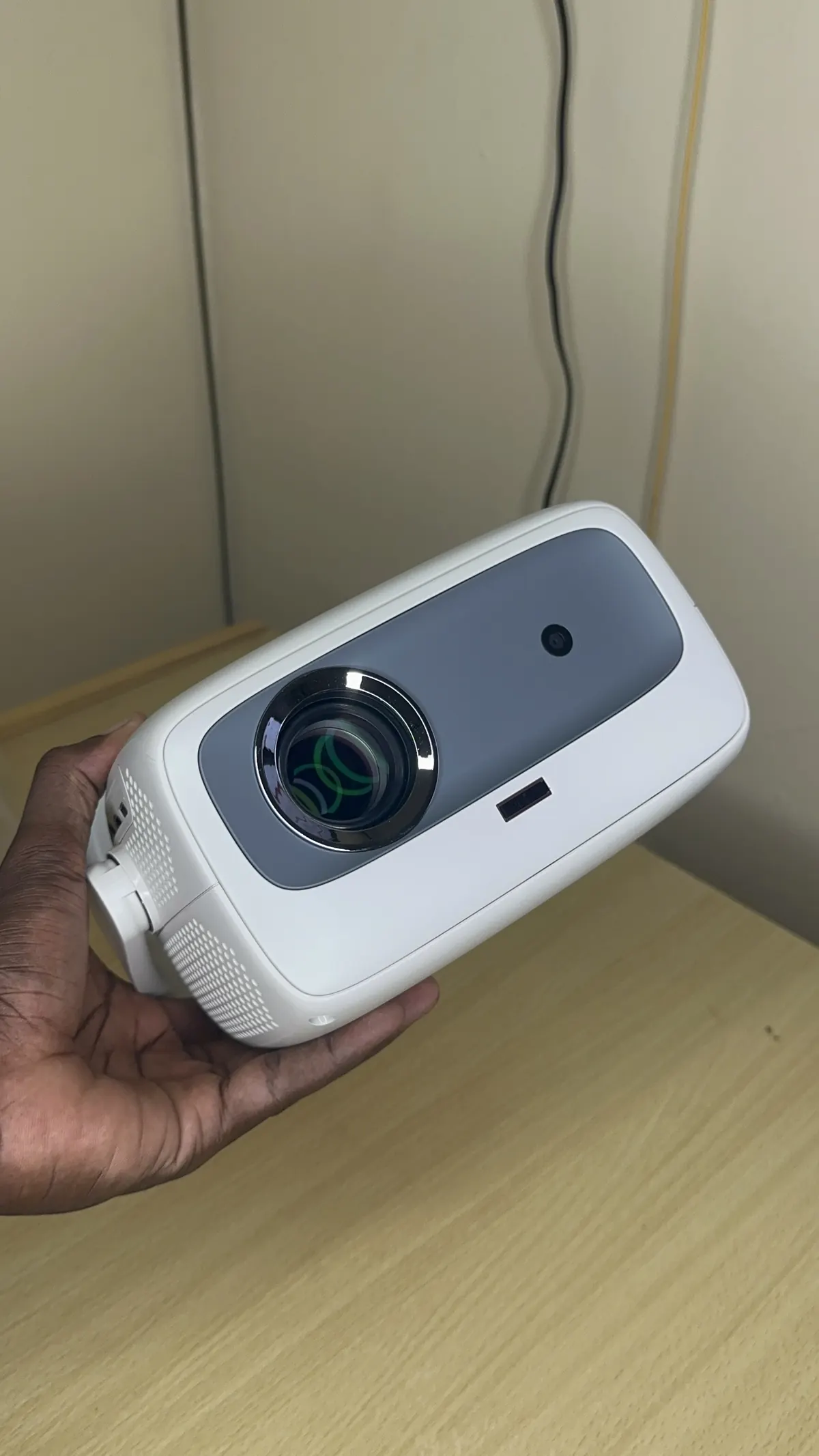 Photo réelle : le projecteur tenu en main, compact